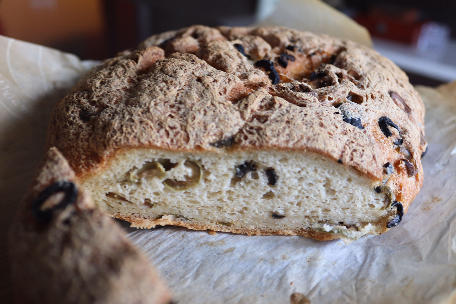 A round loaf of gluten-free olive bread with an open crumb